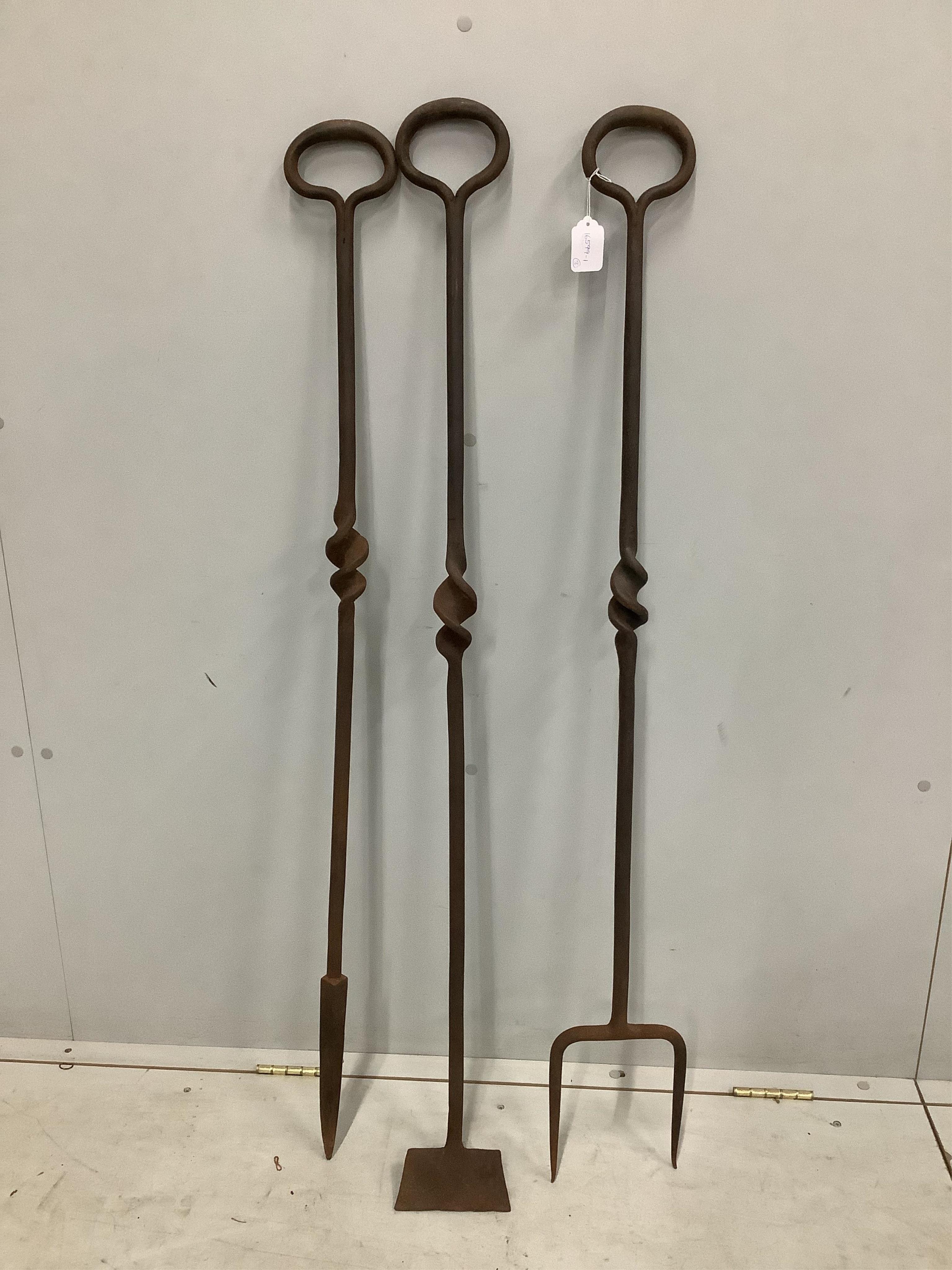 A set of three large wrought iron fire irons, height 129cm. Condition - fair